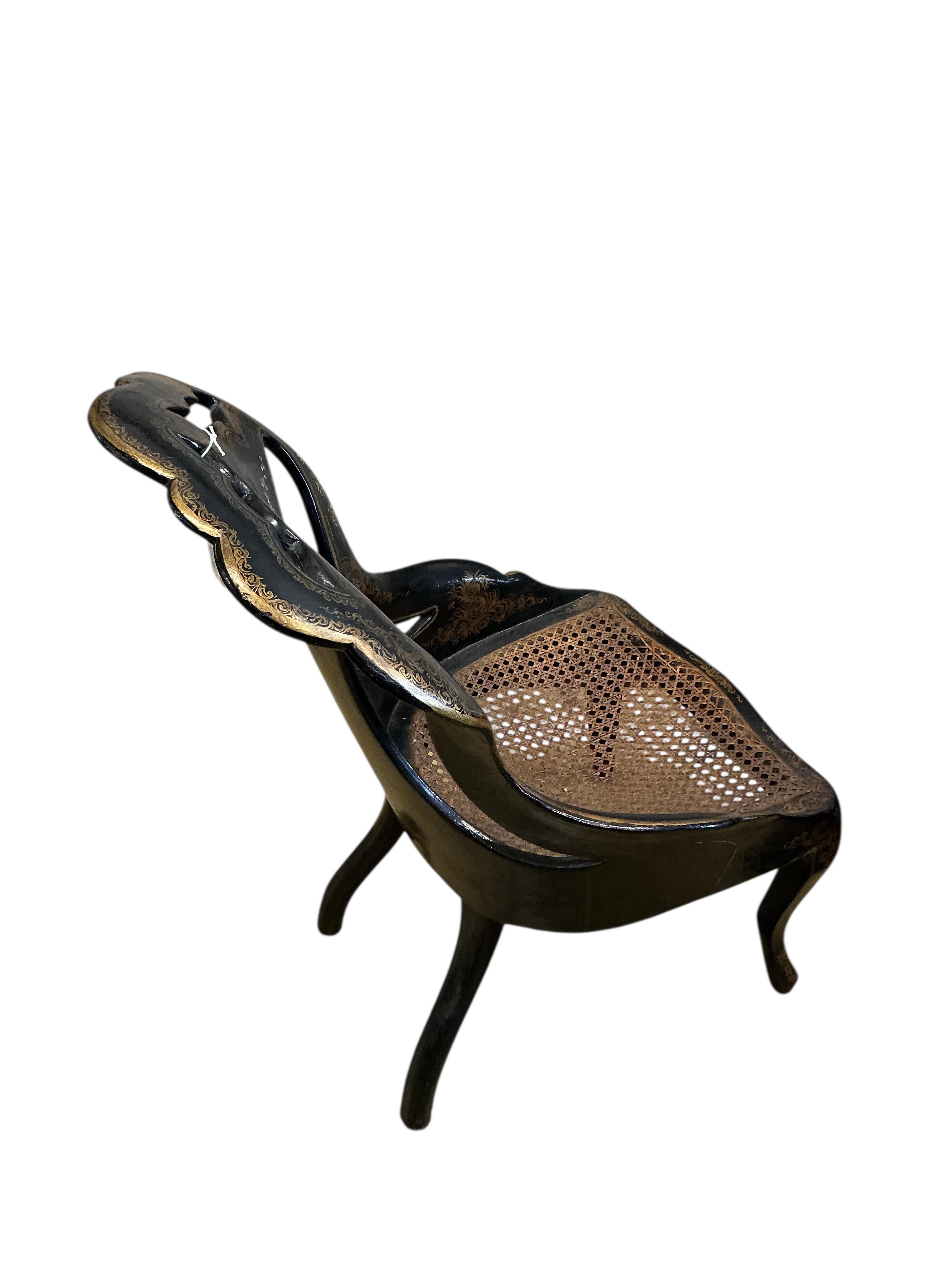 A Victorian mother of pearl inlaid papier-mâché oval tilt top wine table, width 58cm, height 67cm, and a similar cane seat chair